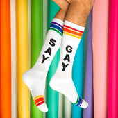 White cotton crew socks with black say and gay lettering and rainbow striped cuffs for bold gay fashion 2026