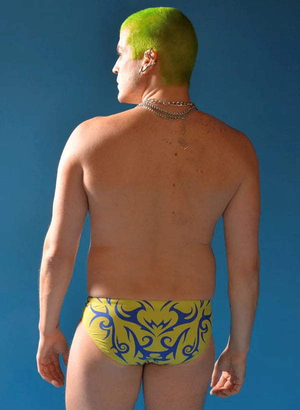 Bright yellow tribal love swim brief with bold blue tribal patterns designed for stylish swimwear use