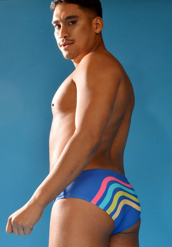 Blue swim trunks with vibrant pink teal and yellow wavy stripes perfect for summer swimwear