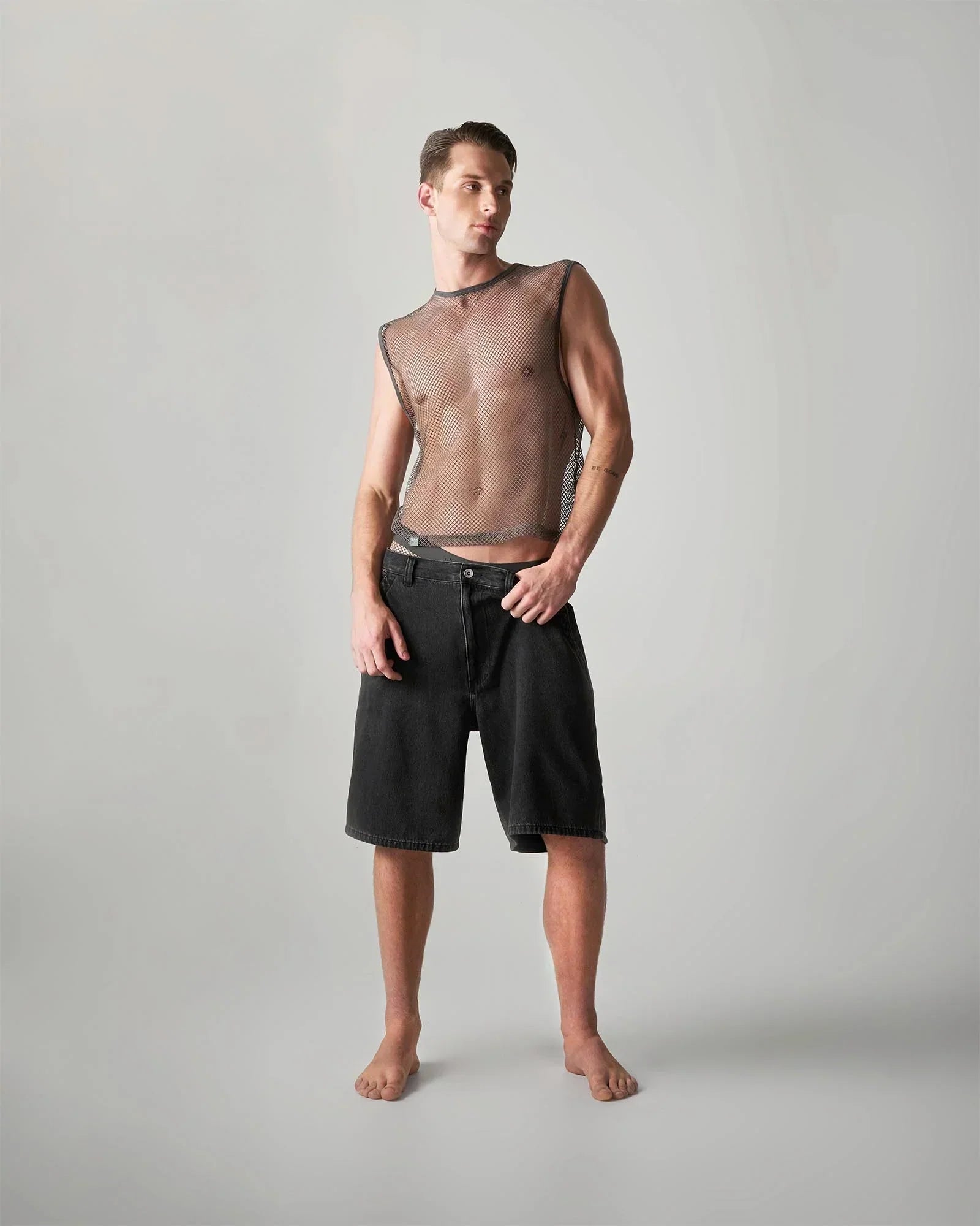 Black denim shorts with straight-leg cut and visible stitching details featured in gay men’s fashion guide 2026.