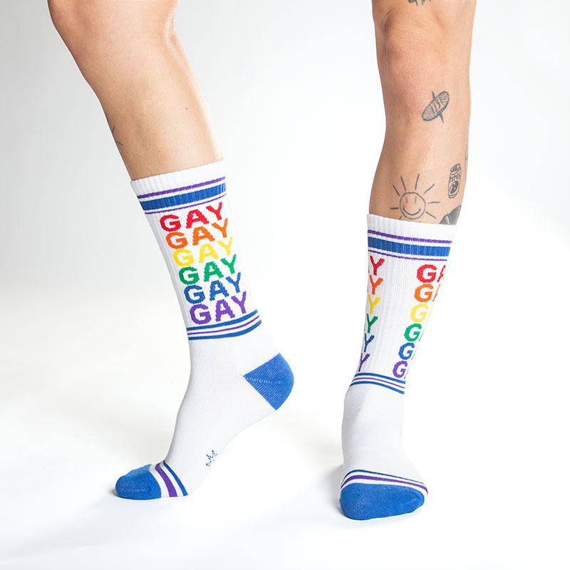 White cotton crew socks with rainbow gay text and blue toe heel and cuff celebrating pride and diversity