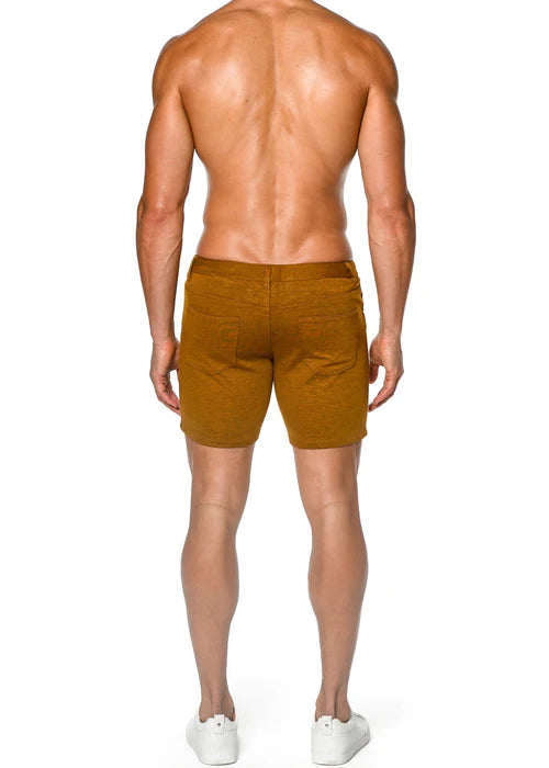 Mens mustard-colored denim shorts with stretch knit fabric and back pockets shown from the back side