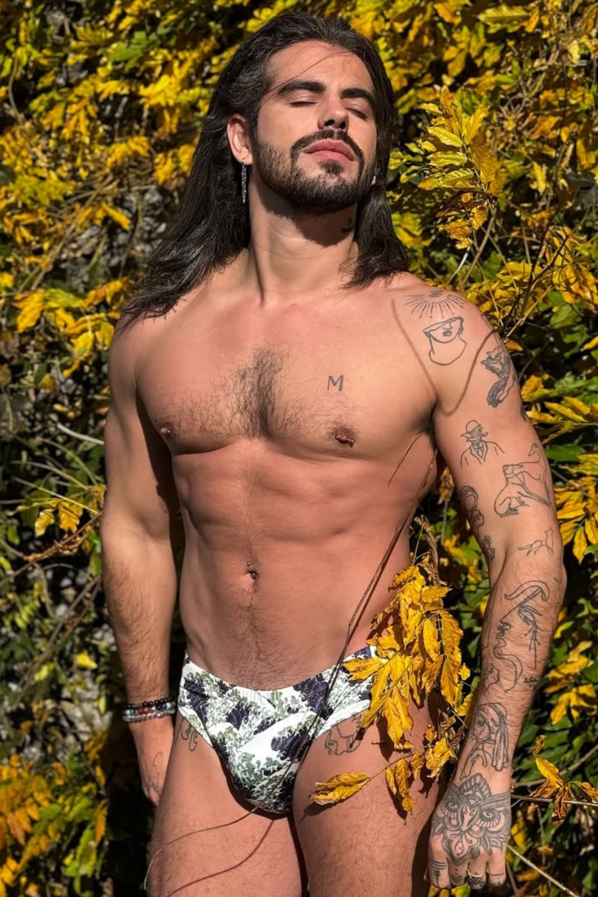 Model showcasing bold patterned briefs from the Gay Men's Swimwear Trends collection.