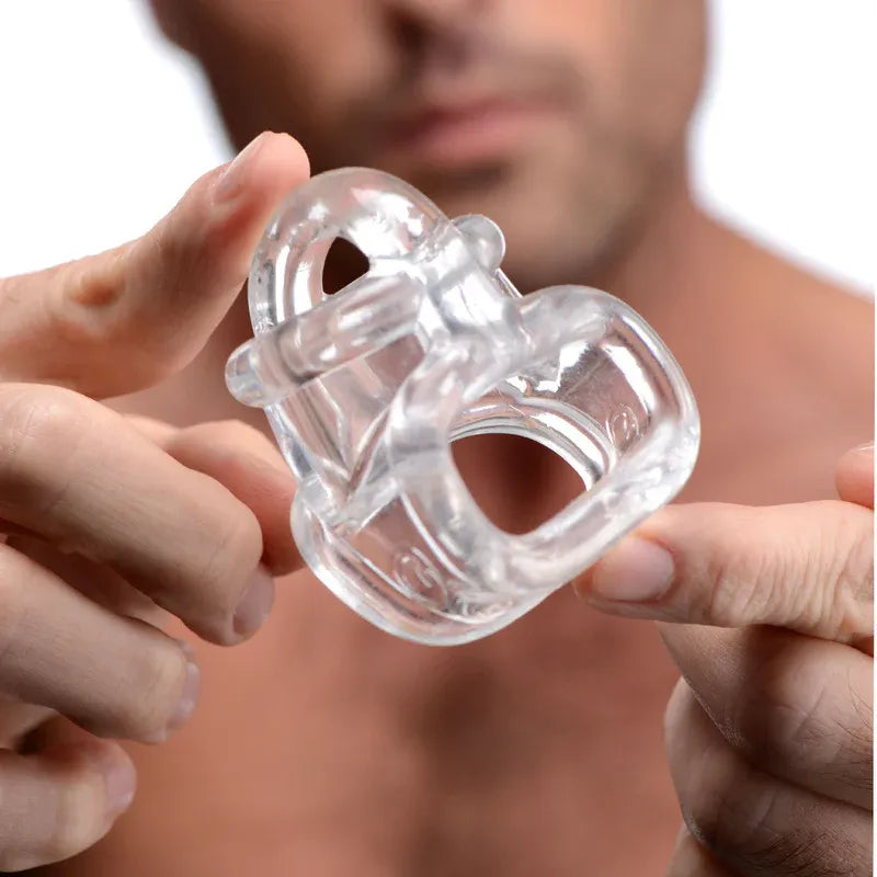 Man holding steel cock ring and butt plug toy while smiling