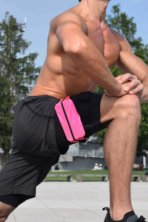 Bright pink athletic waist pouch with black trim worn on a man’s shorts showcasing ssbag running belt features