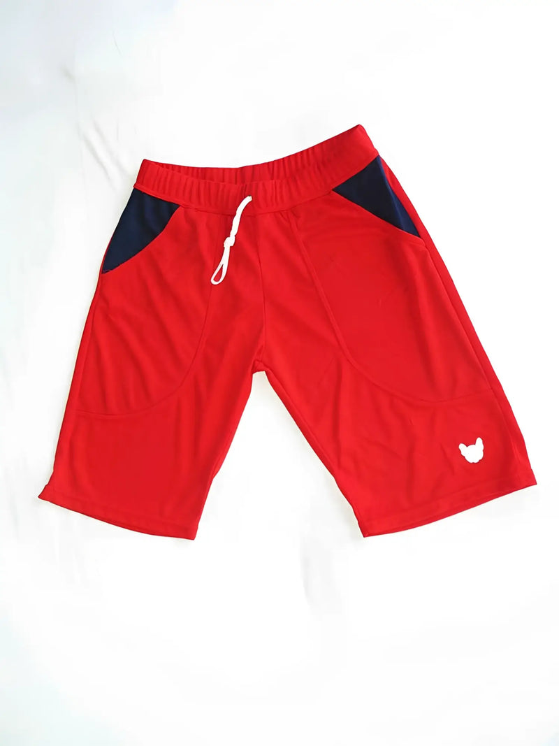 Red athletic shorts with dark blue pockets and drawstring on white background.