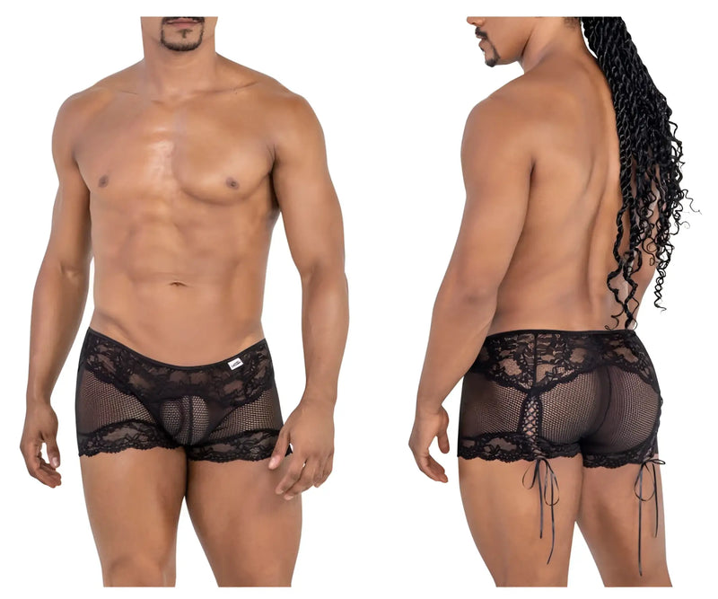 Man wears black lace fishnet boxer briefs with ribbon ties, white background.