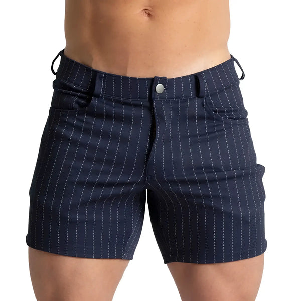 Shirtless male model wearing dark blue pinstriped shorts against white background.
