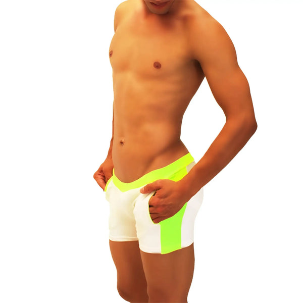 A man poses wearing white form-fitting shorts with neon green side panels.