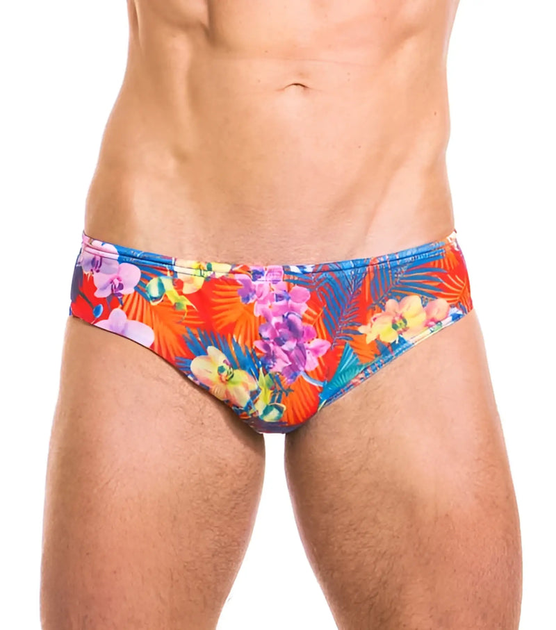 Torso of man wearing red swim briefs with colorful tropical flower pattern.