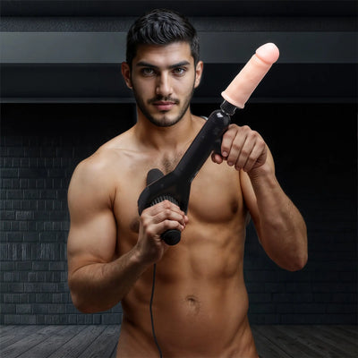 Shirtless man holding a black handheld device against a dark brick background.
