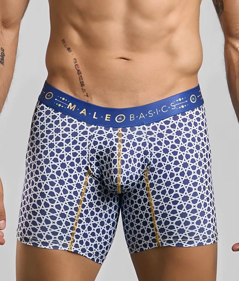 Blue boxer briefs with white geometric patterns worn by a muscular man.