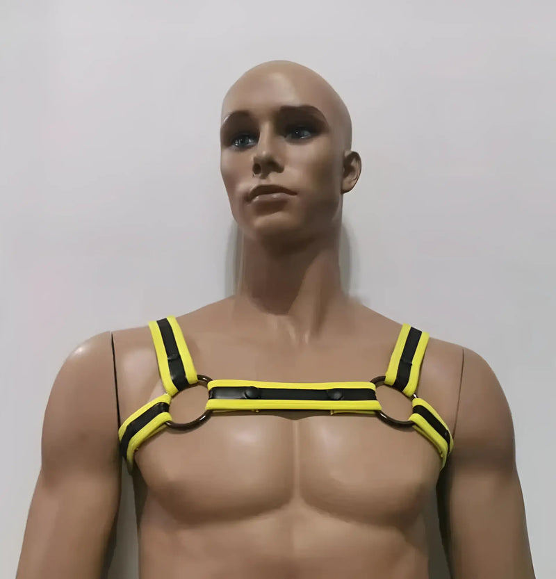 A male mannequin wears a yellow and black strap harness against white.