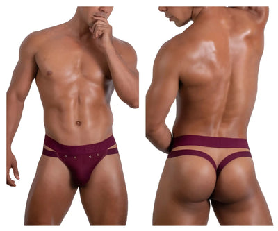 Muscular man wearing burgundy thong with metal grommets against white background.