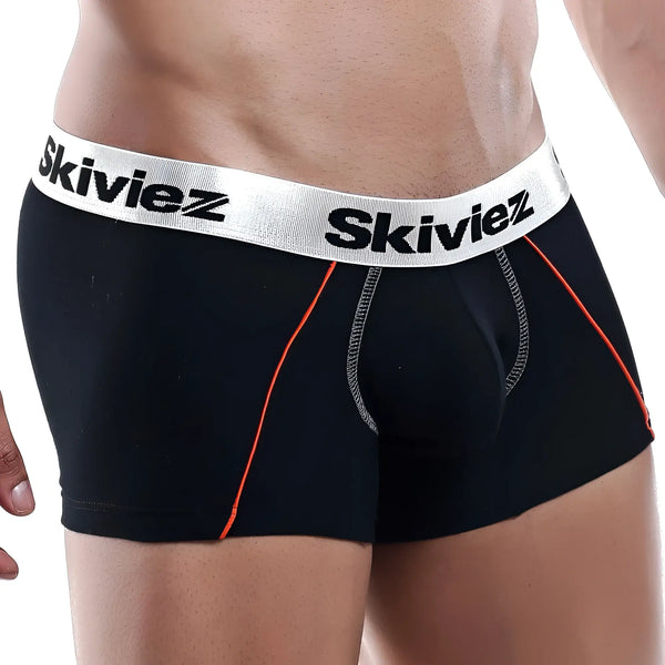 A person wears black boxer briefs with orange piping against white background.