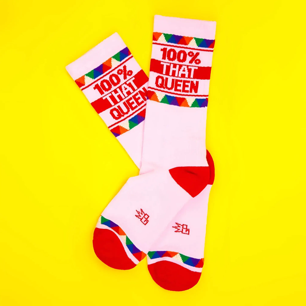 White crew socks with red accents and colorful triangular patterns featuring bold red text 100% that queen