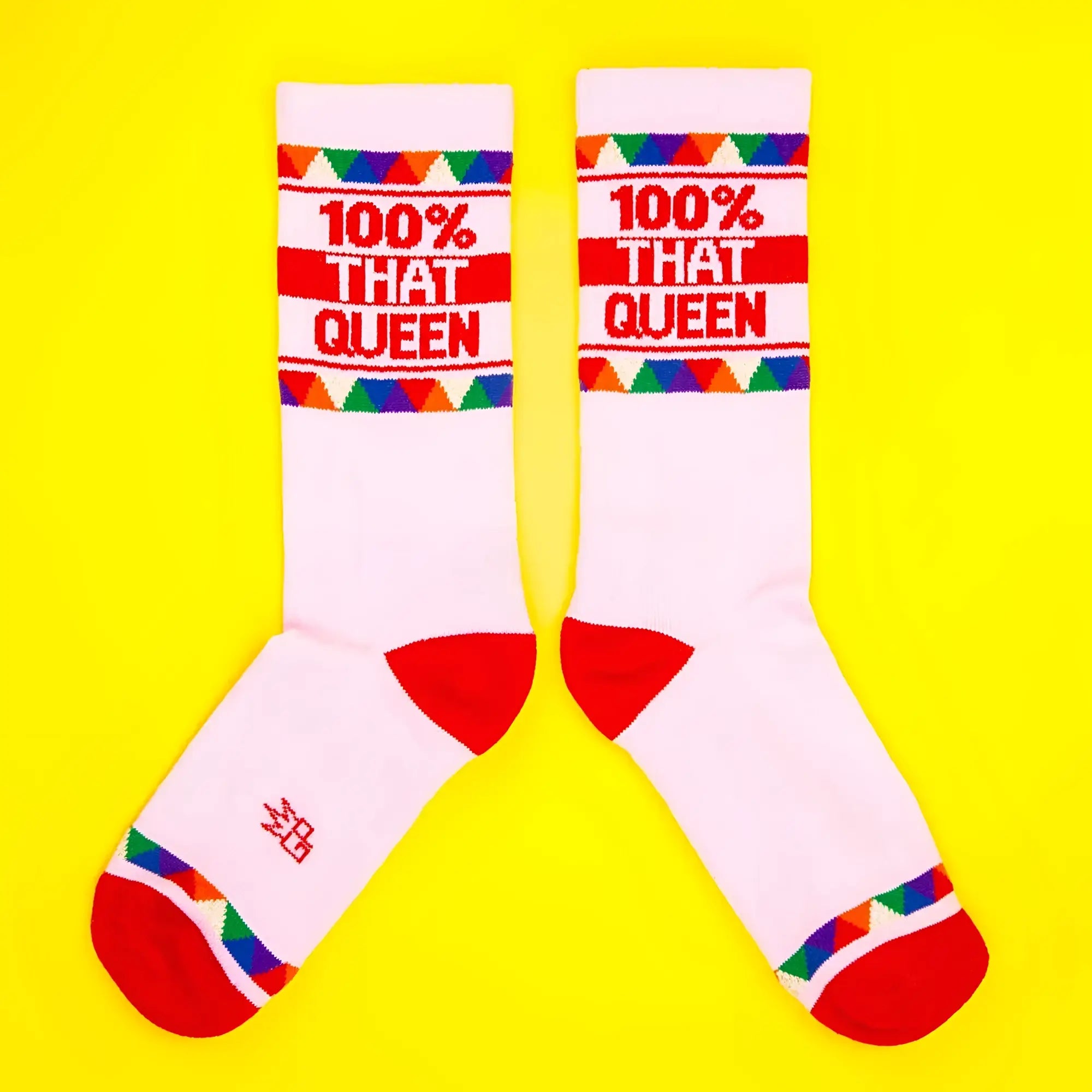 White crew socks with red toe and heel accents featuring bold 100 percent that queen text and colorful cuff patterns