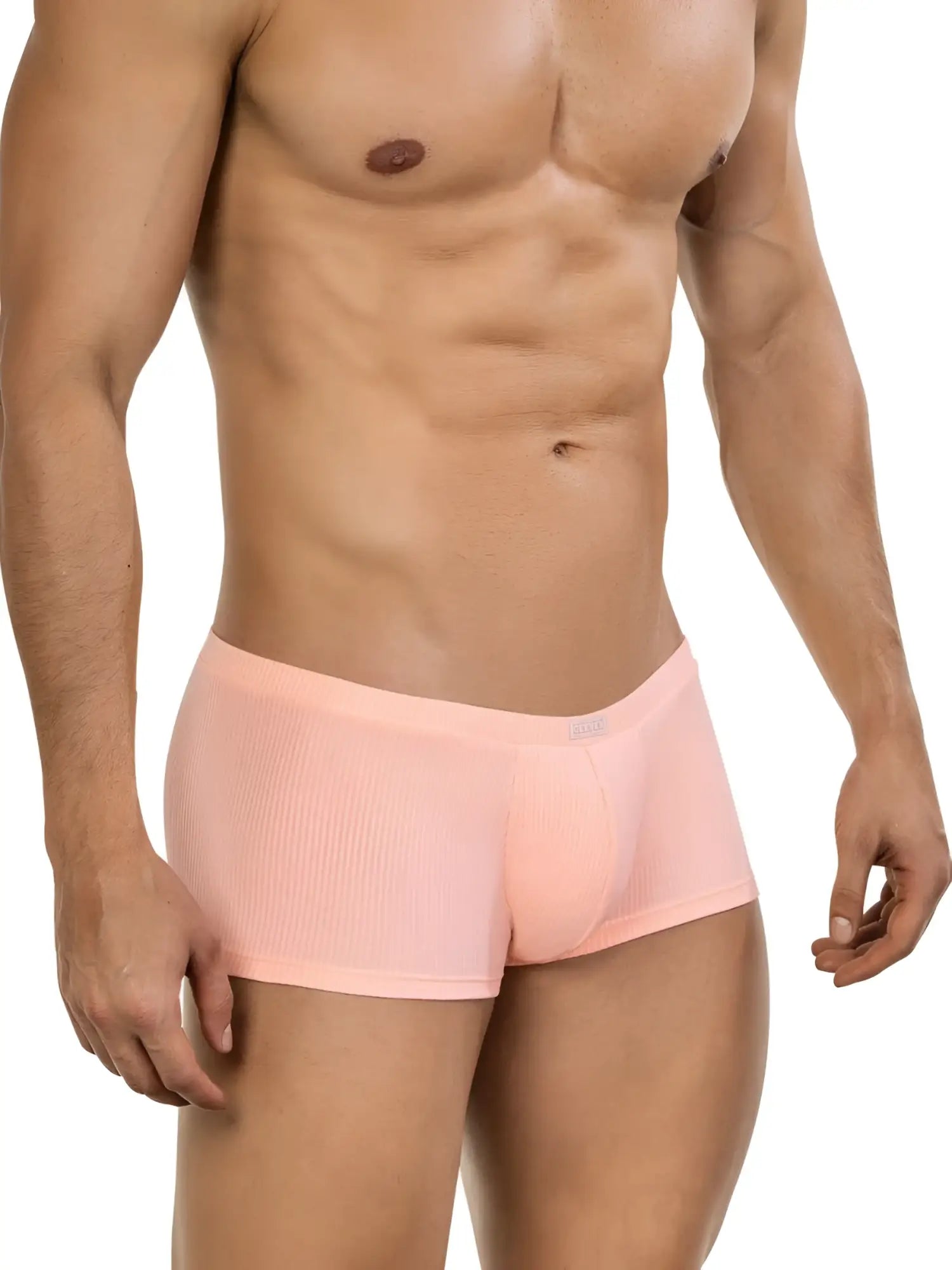 Model wearing 26014 Apolo trunks in orange, featuring a fitted, ribbed-fabric design with a contoured pouch.