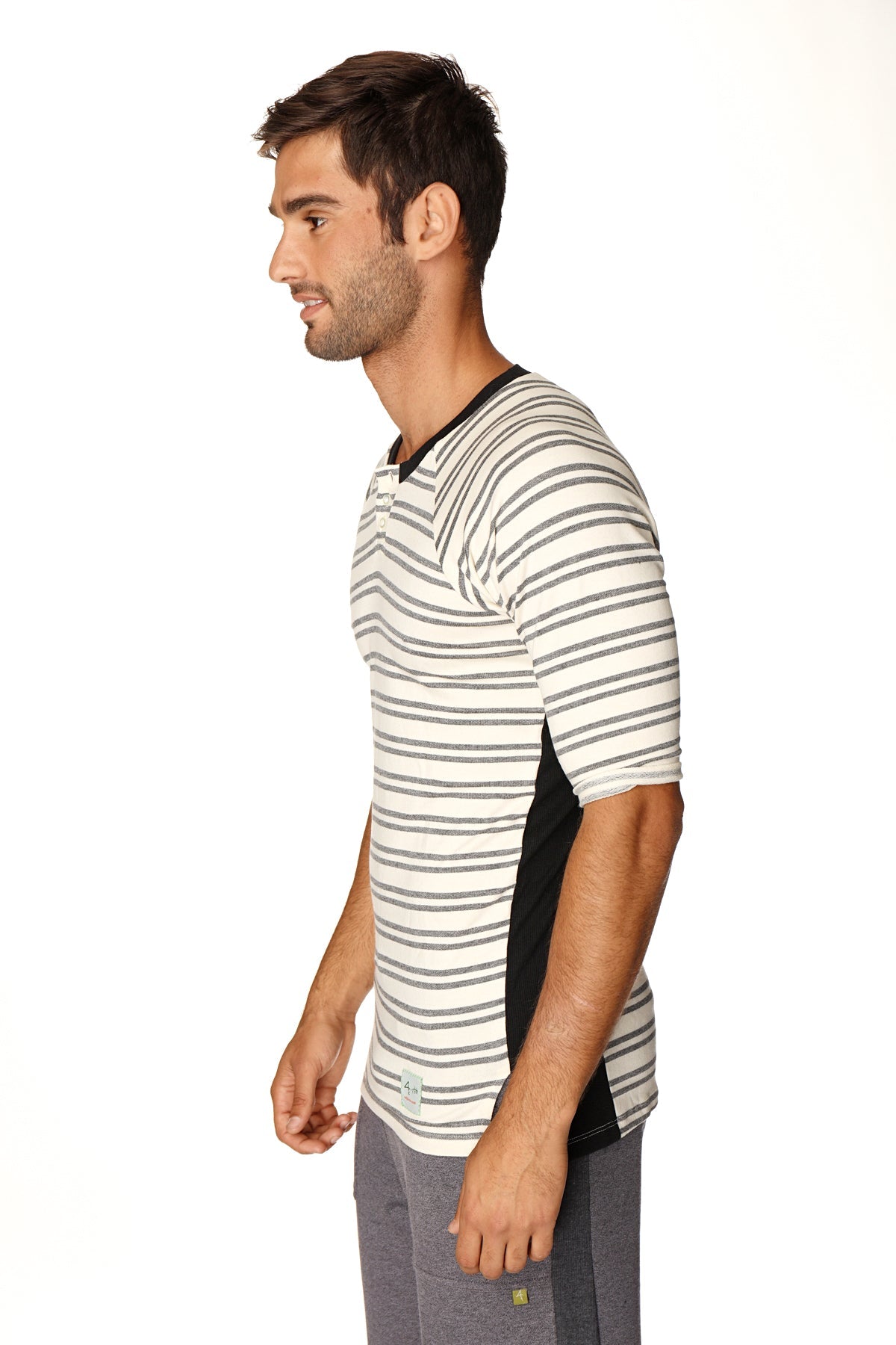 A man wearing a dark grey double stripe 4-rth mens vintage-stripe henley tee in french terry loop with black side panels