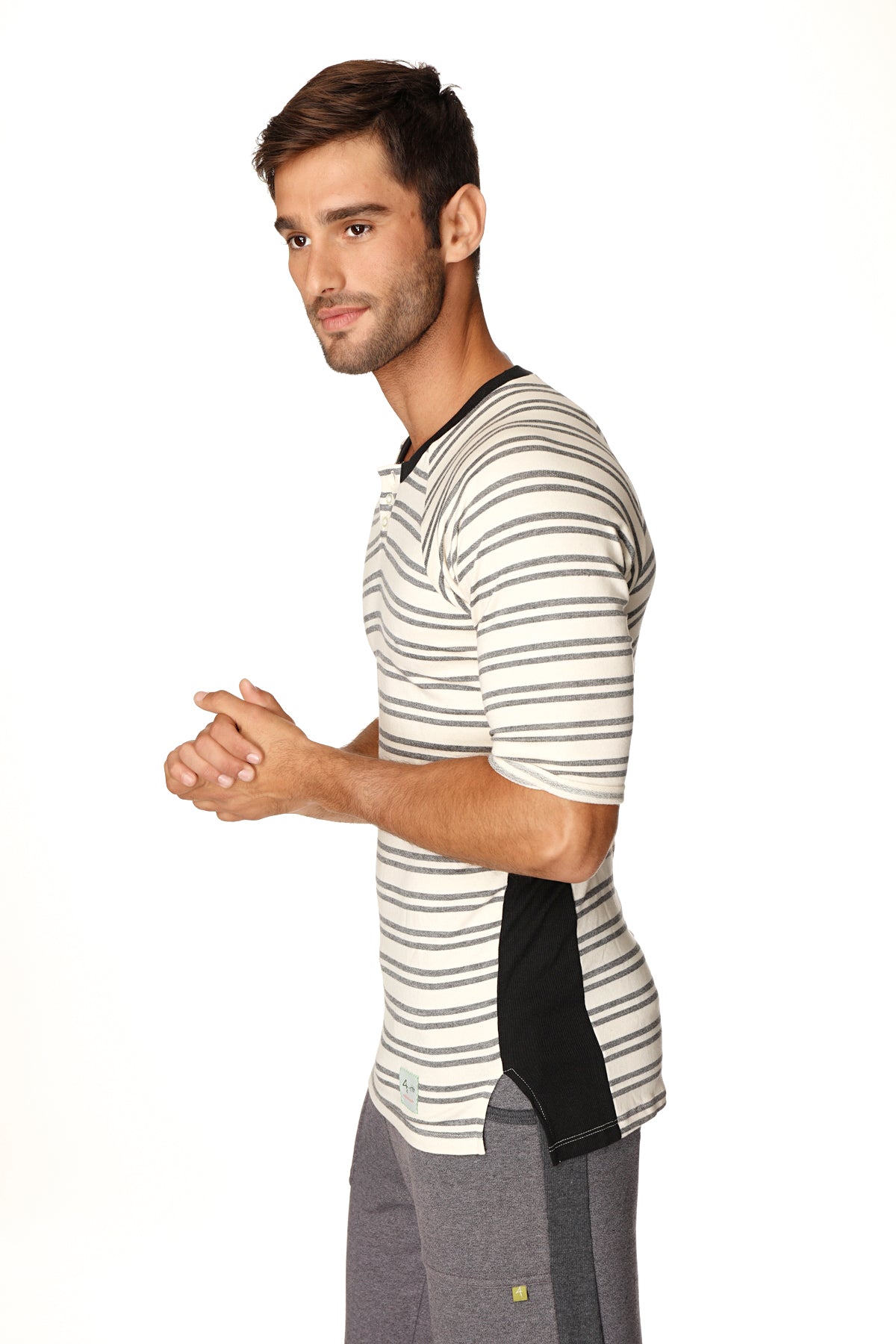 A man wearing a dark grey double stripe 4-rth mens vintage-stripe henley tee in french terry loop with black side panels