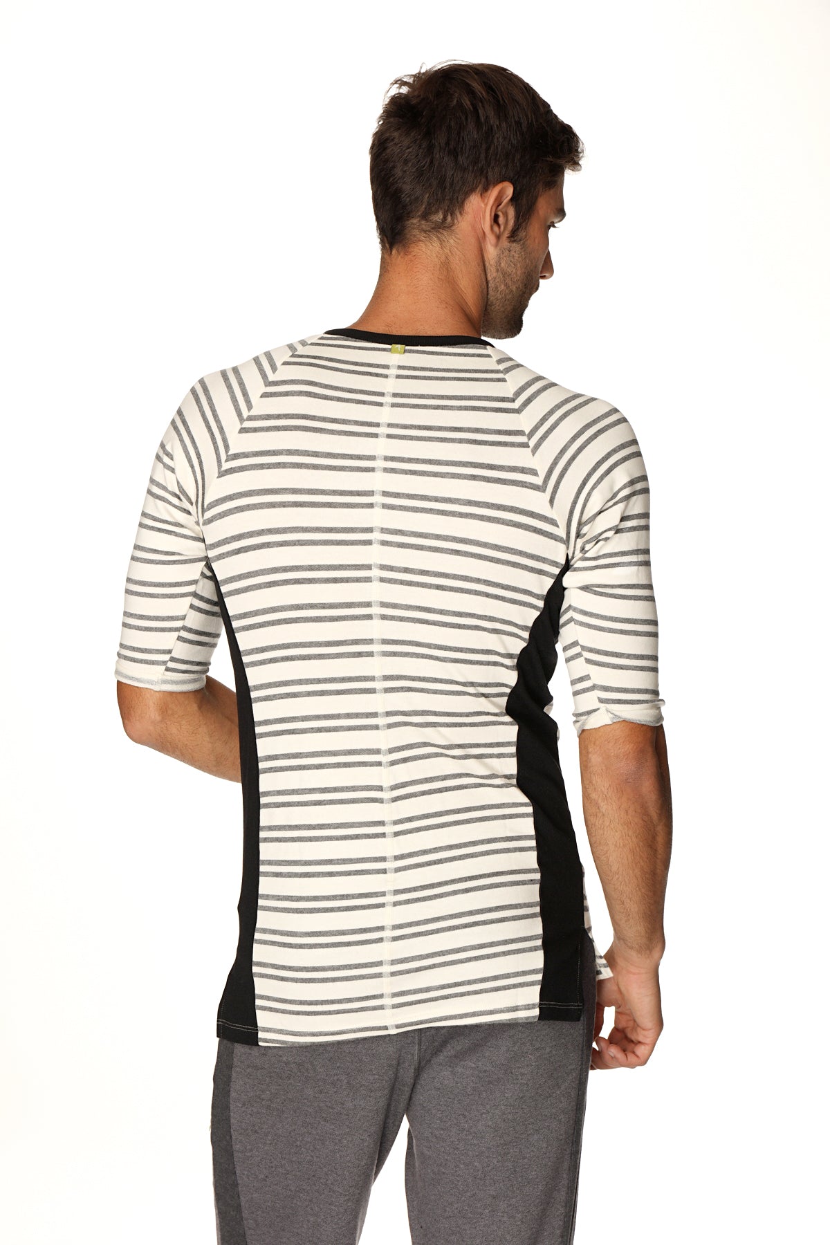 A men’s short-sleeved 4-rth vintage-stripe henley tee in dark grey double stripe french terry loop with black panels and green button