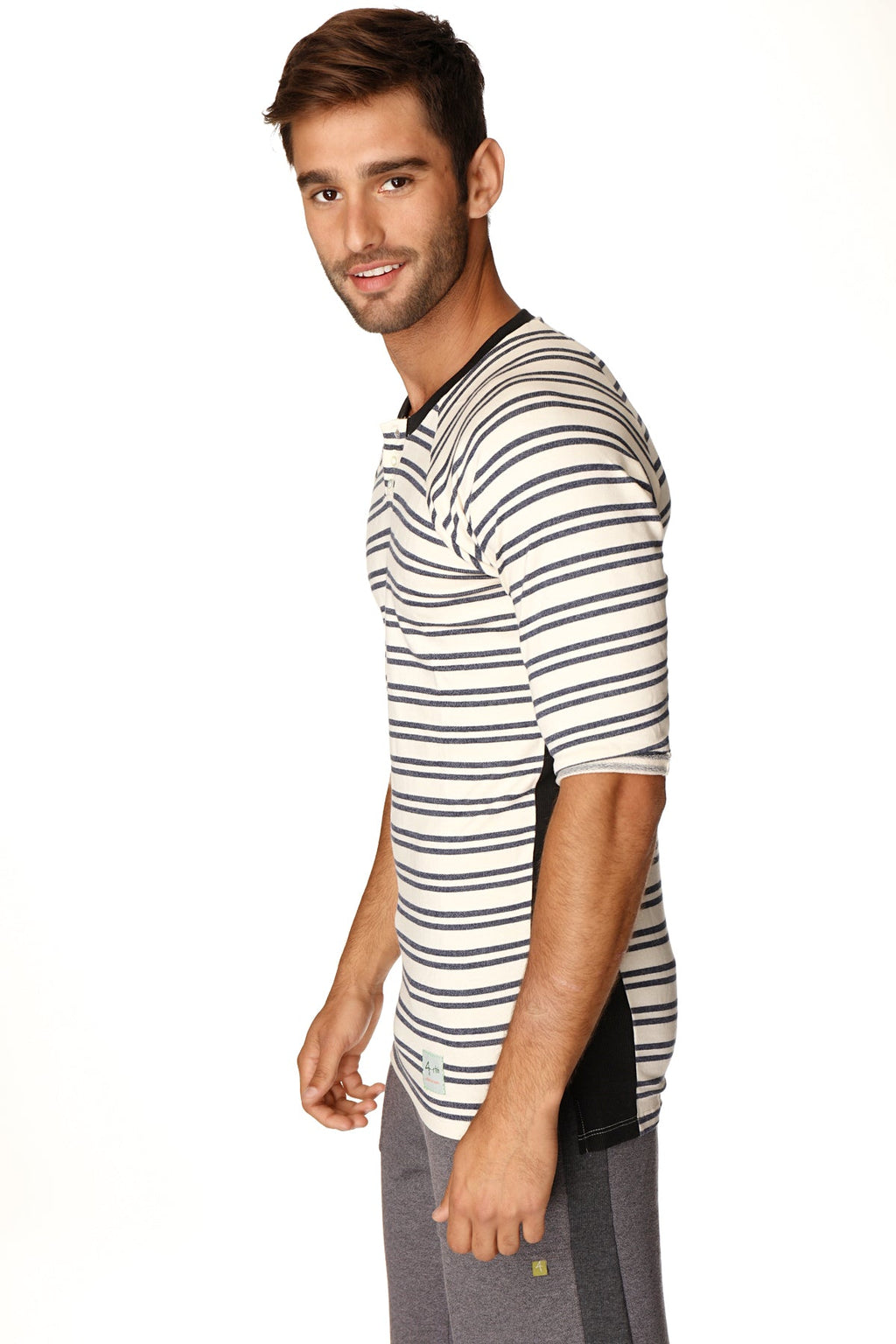 A man wearing a 4-rth mens vintage-stripe henley tee with black and white stripes and black side panels in french terry