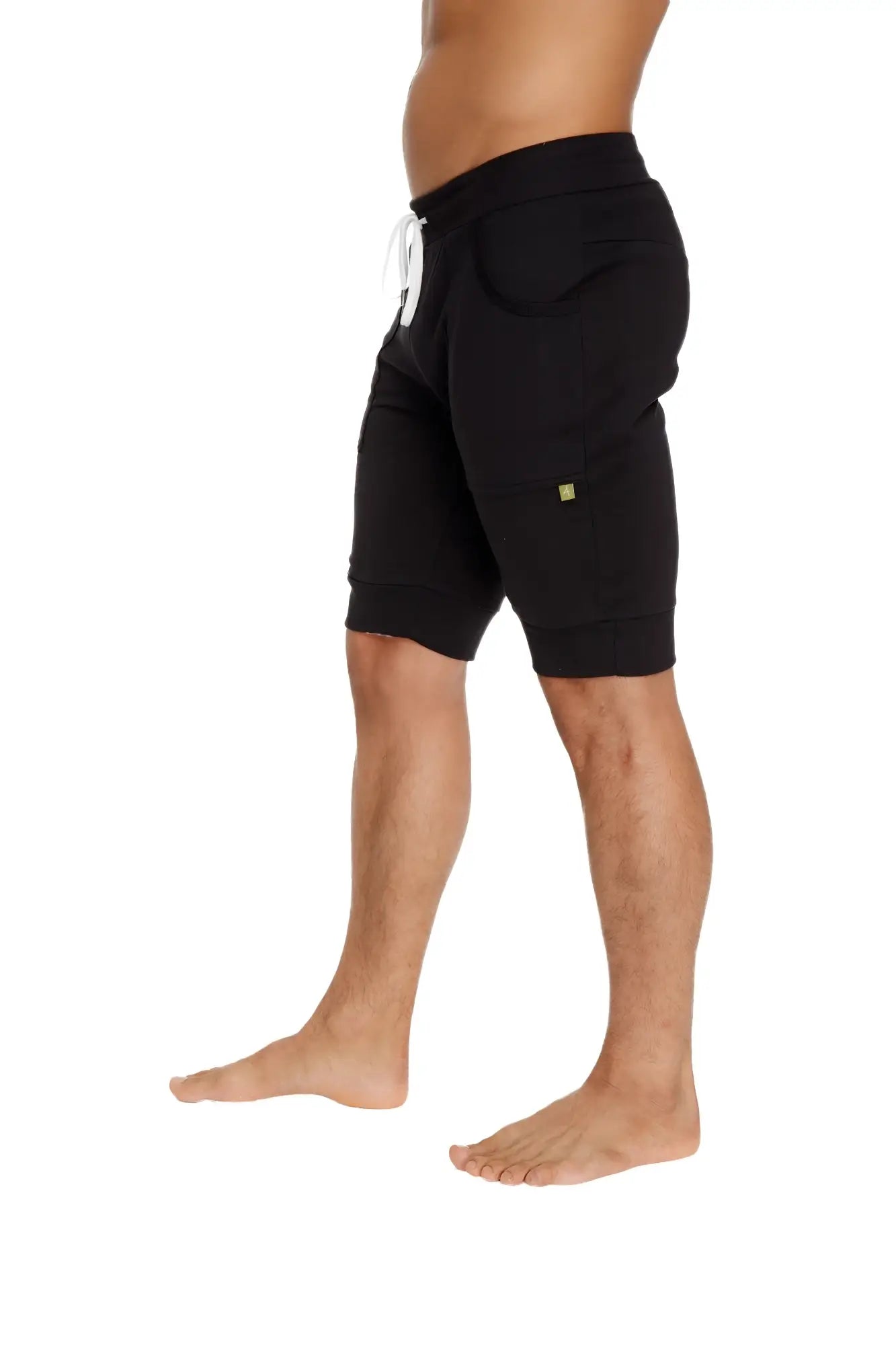 Black cuffed yoga shorts made of cotton with a white drawstring and small green logo on the side