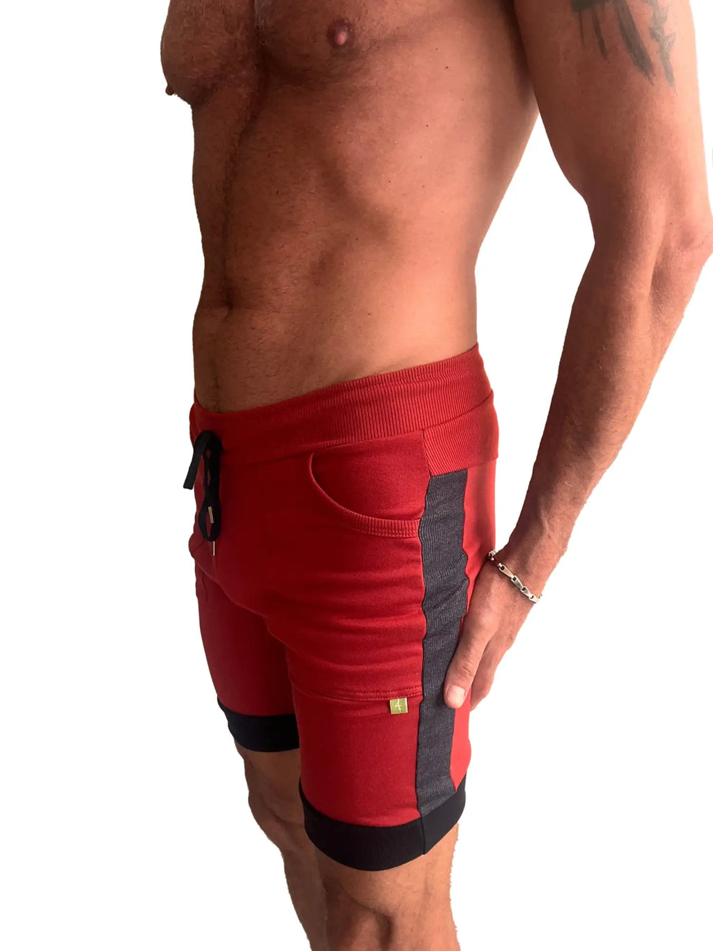 Red cuffed yoga shorts with black and charcoal ribbed waistband and contrasting side panels for athletic wear