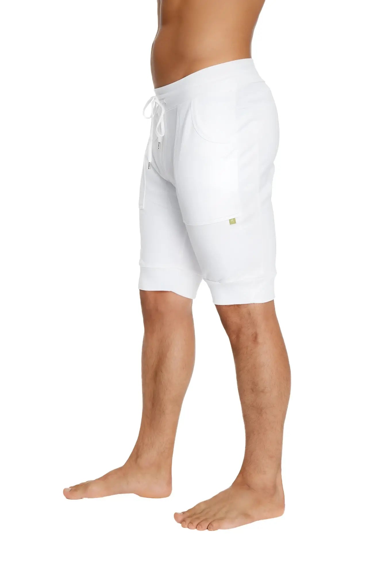 White cuffed yoga shorts made of soft stretchy fabric with a subtle green logo on the side
