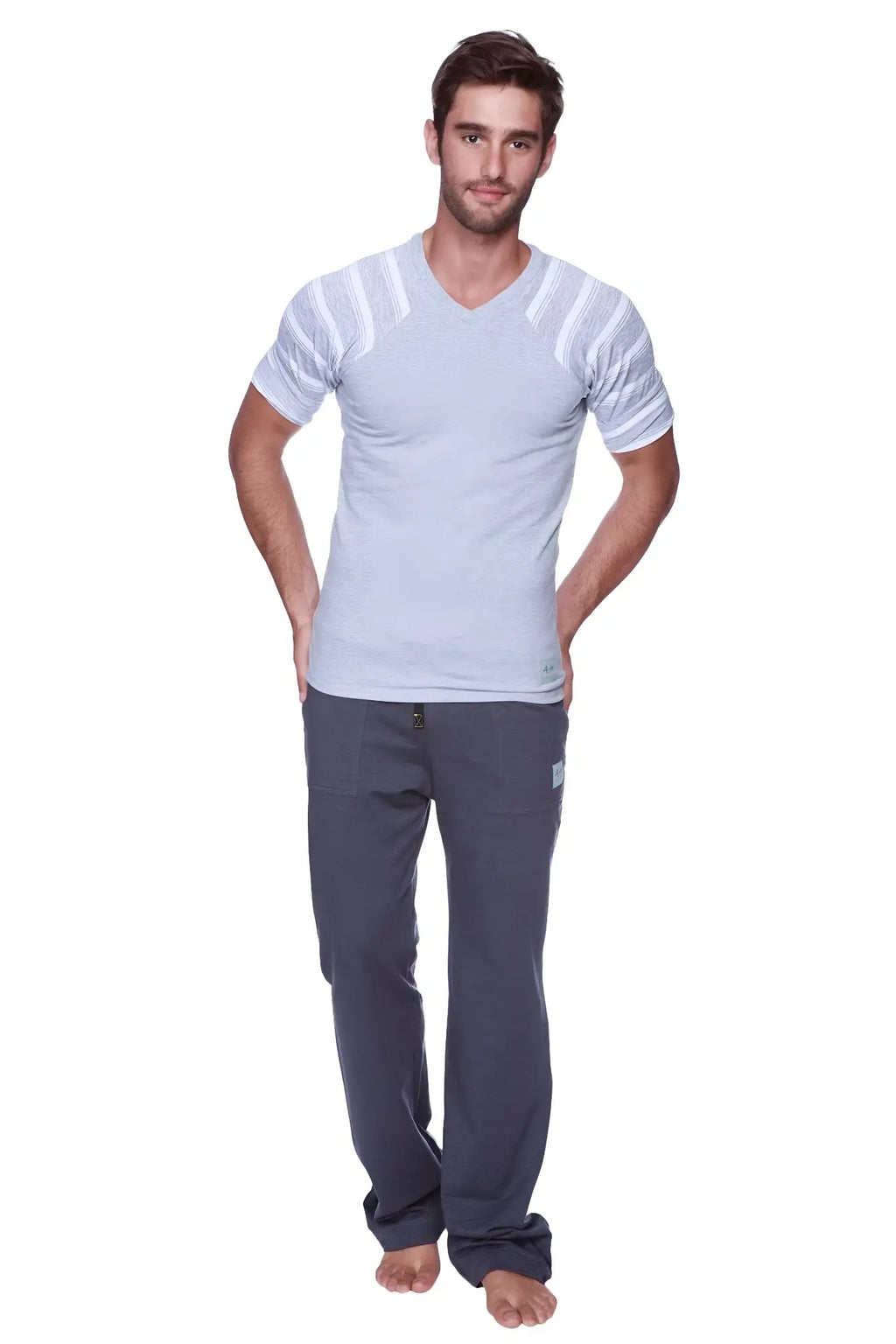 A man wearing charcoal eco-track and yoga sweat pant with royal blue detail and a light gray v-neck t-shirt with white stripes
