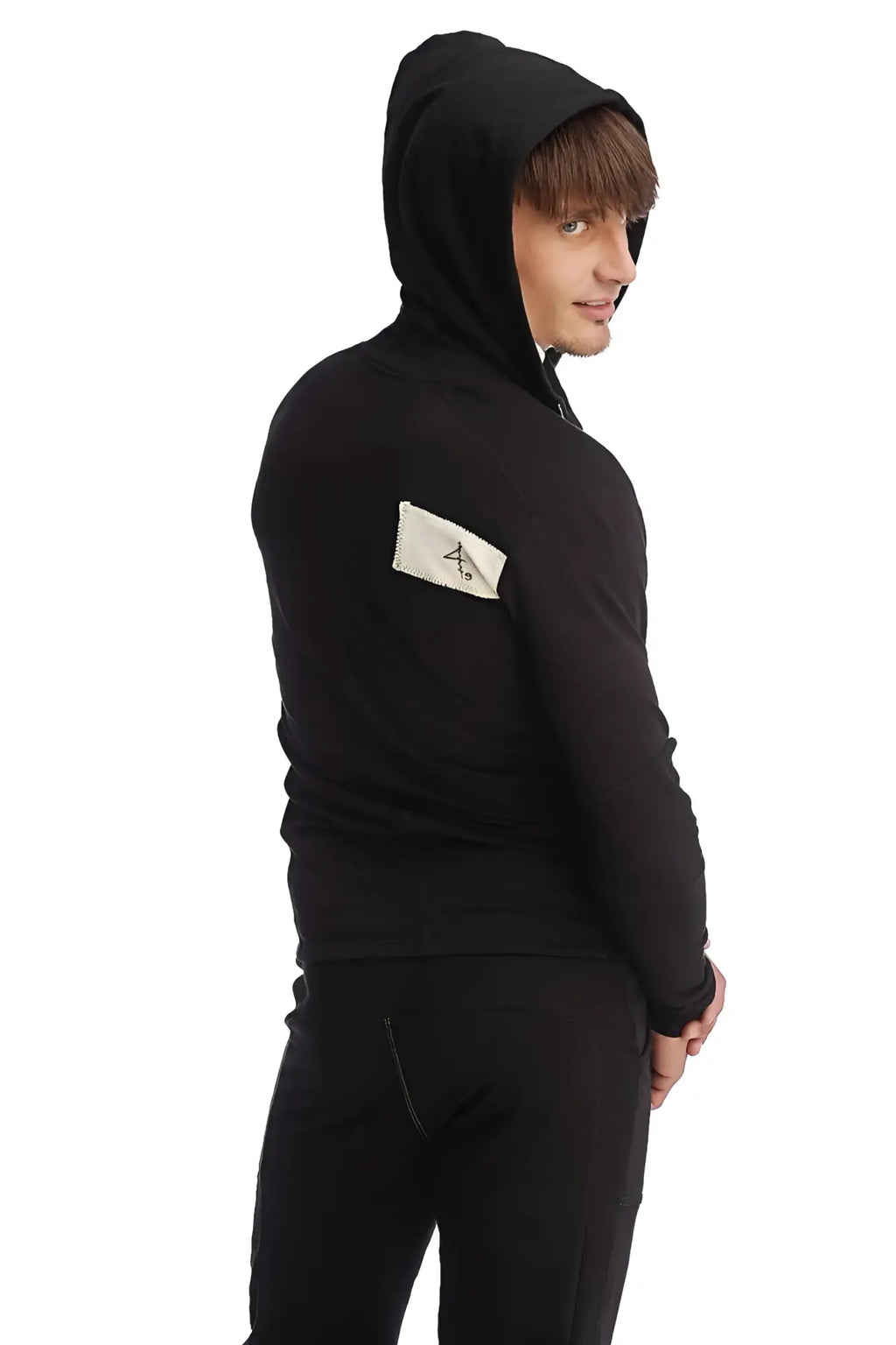 Black edge form-fit crossover yoga track hoodie with white rectangular logo patch on left sleeve for performance wear