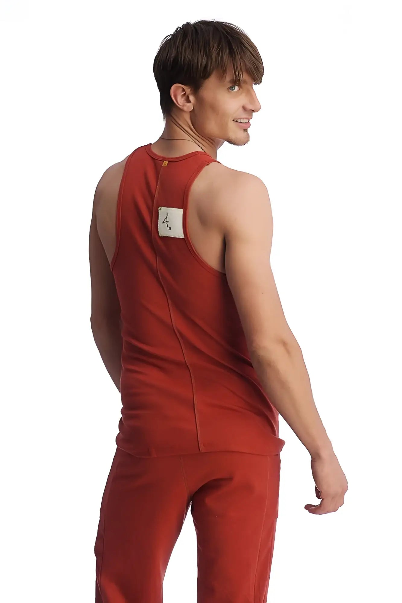 Back view of red cinnabar edge sustain tank top with white label showing sleeveless design and lightweight fabric