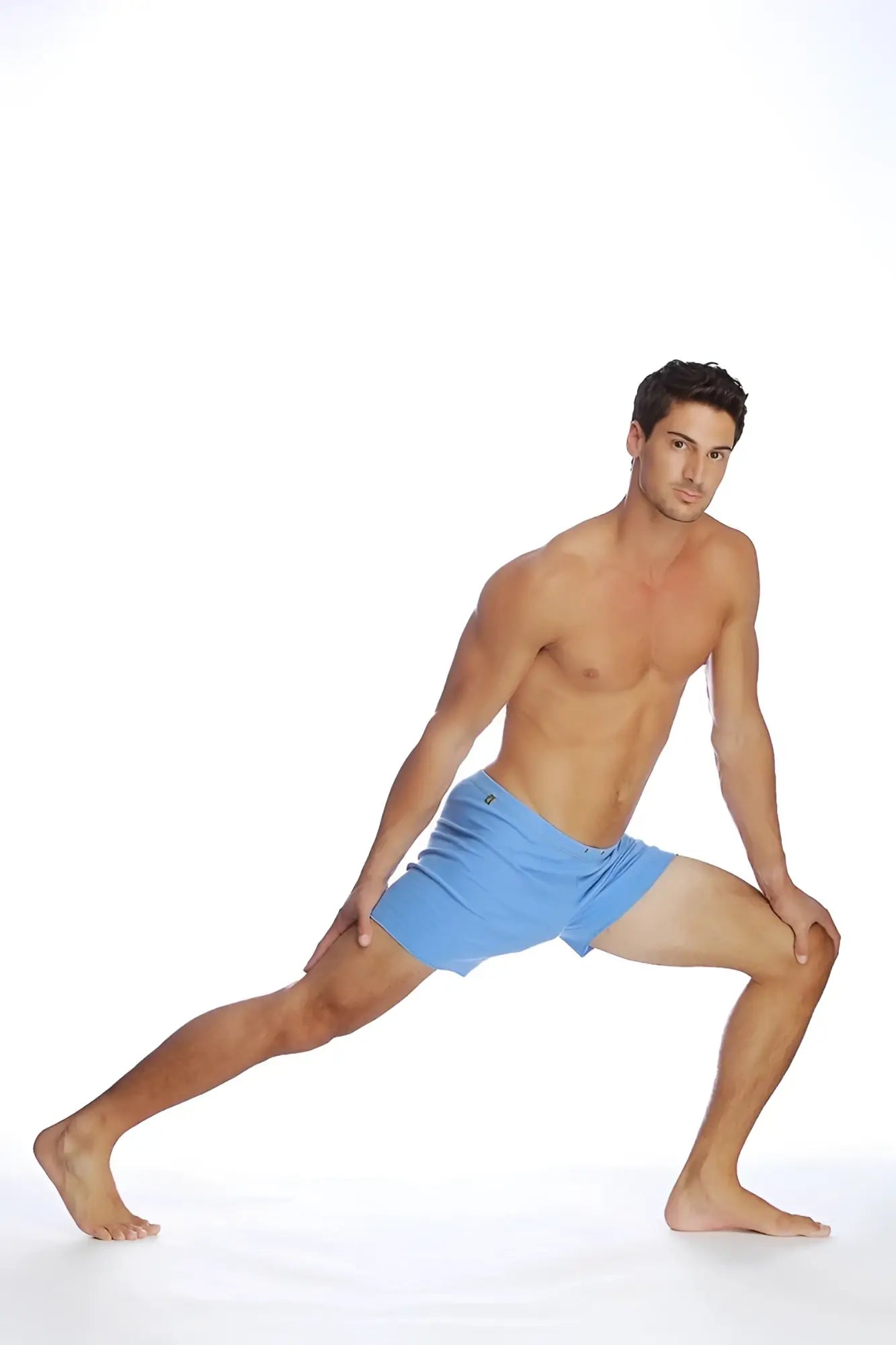 A man wearing light blue fusion yoga shorts designed for comfort and flexibility during athletic activities