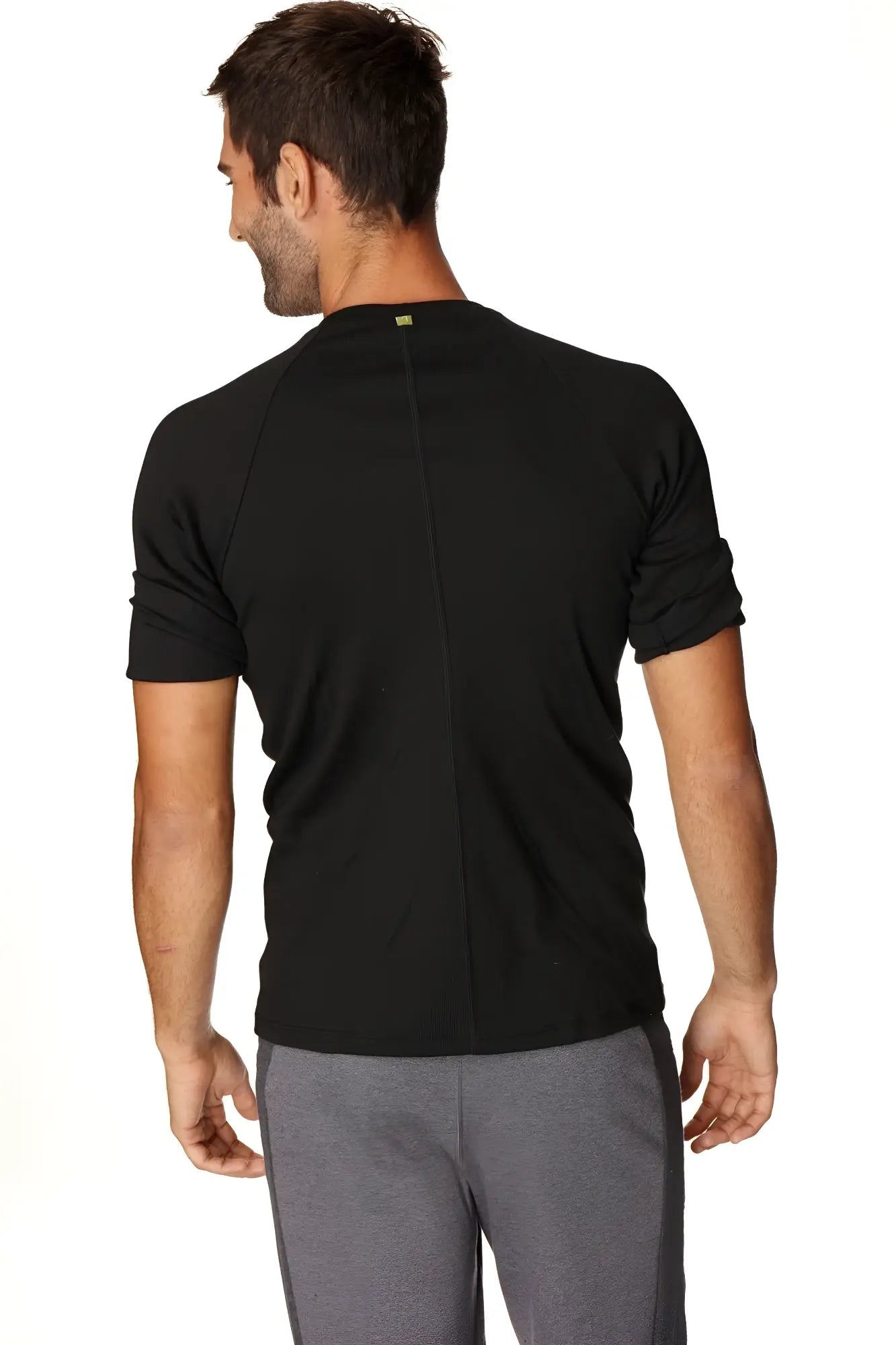 Back view of hybrid crew neck raglan tee black short-sleeved athletic shirt with vertical seam and green logo