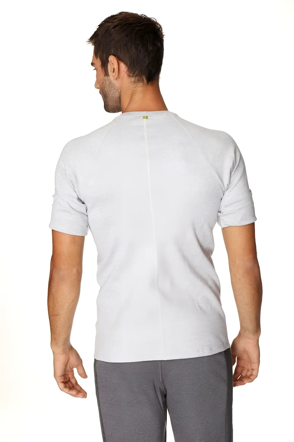 Back view of a heather grey hybrid crew neck raglan tee with a subtle vertical seam and small green logo at neckline