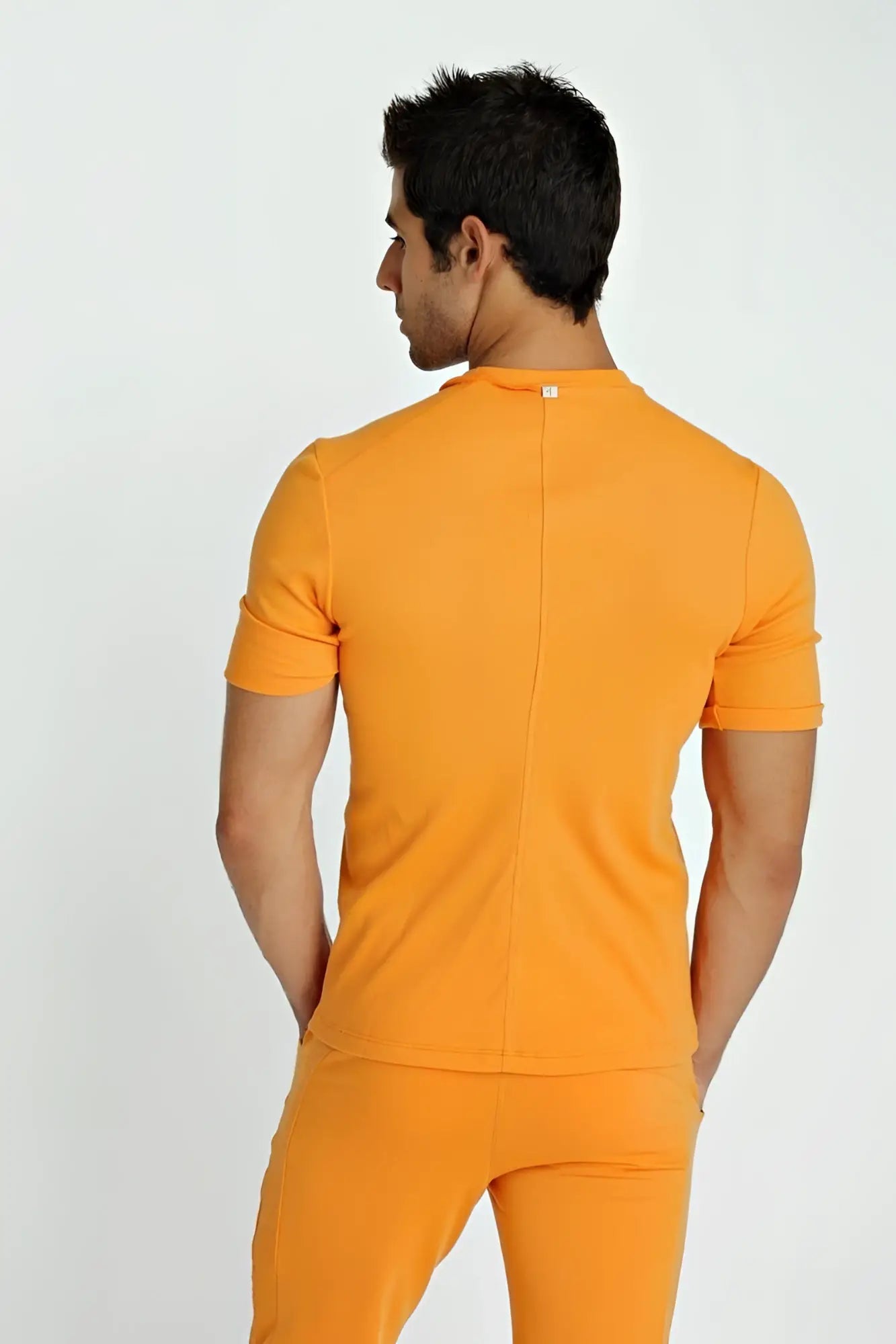 Orange short-sleeved fitted hybrid v-neck t-shirt with central back seam and subtle brand tag at neckline back side view