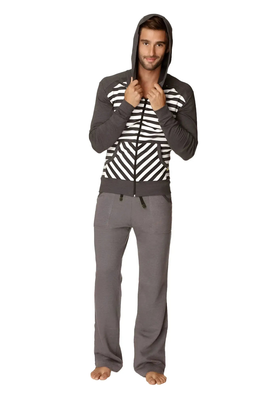 A man wearing a charcoal stripe original limited edition form-fit crossover yoga track performance fleece hoodie with matching pants