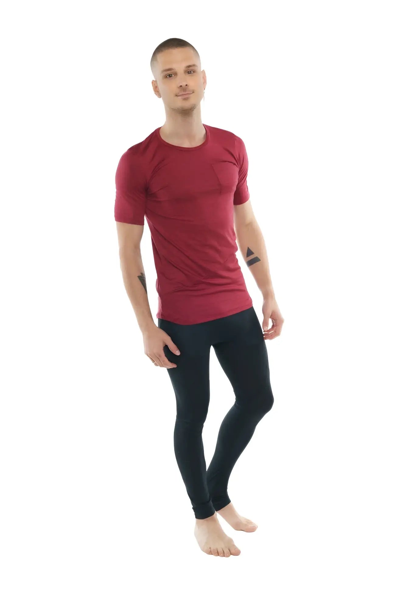 A man wearing a fitted brick red heather perfect pocket crew-neck tee with short sleeves and black athletic leggings