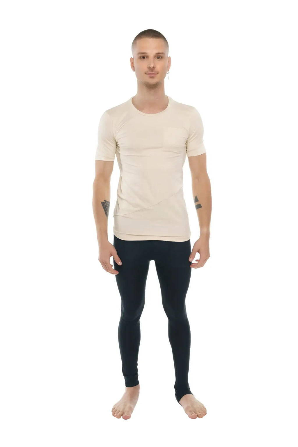 A man wearing a beige fitted perfect pocket crew-neck tee with short sleeves paired with black leggings