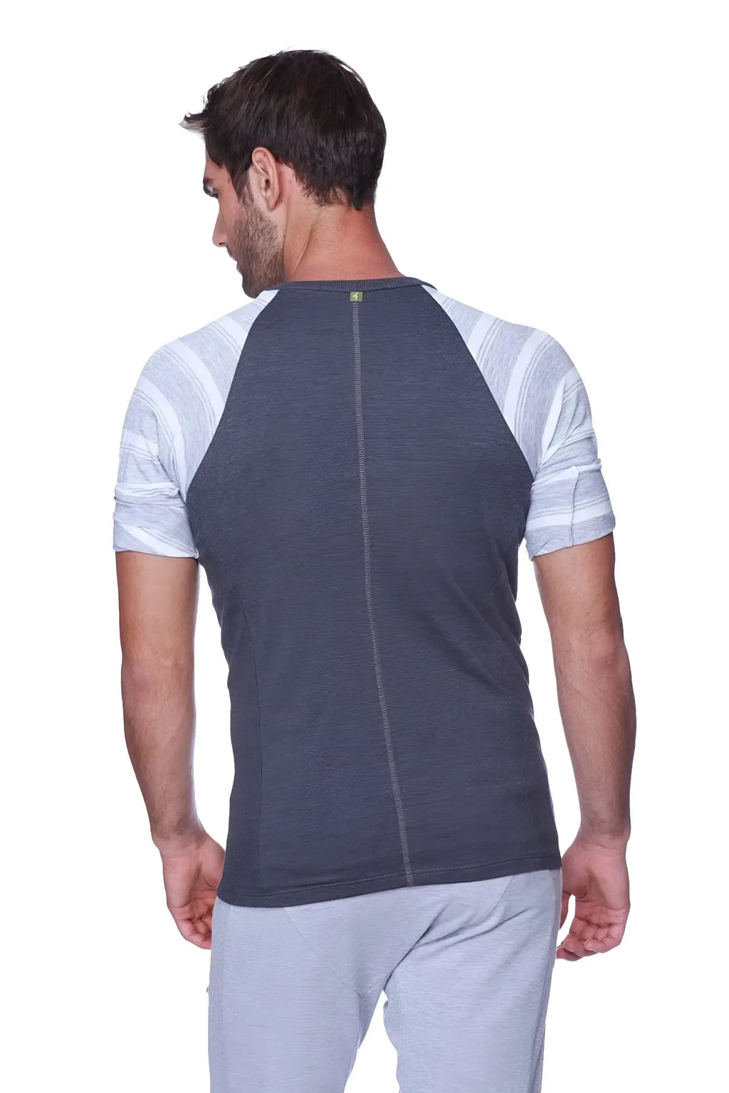 Back view of a dark gray and light gray striped raglan sleeve t-shirt with a central zipper raglan virtual crew neck
