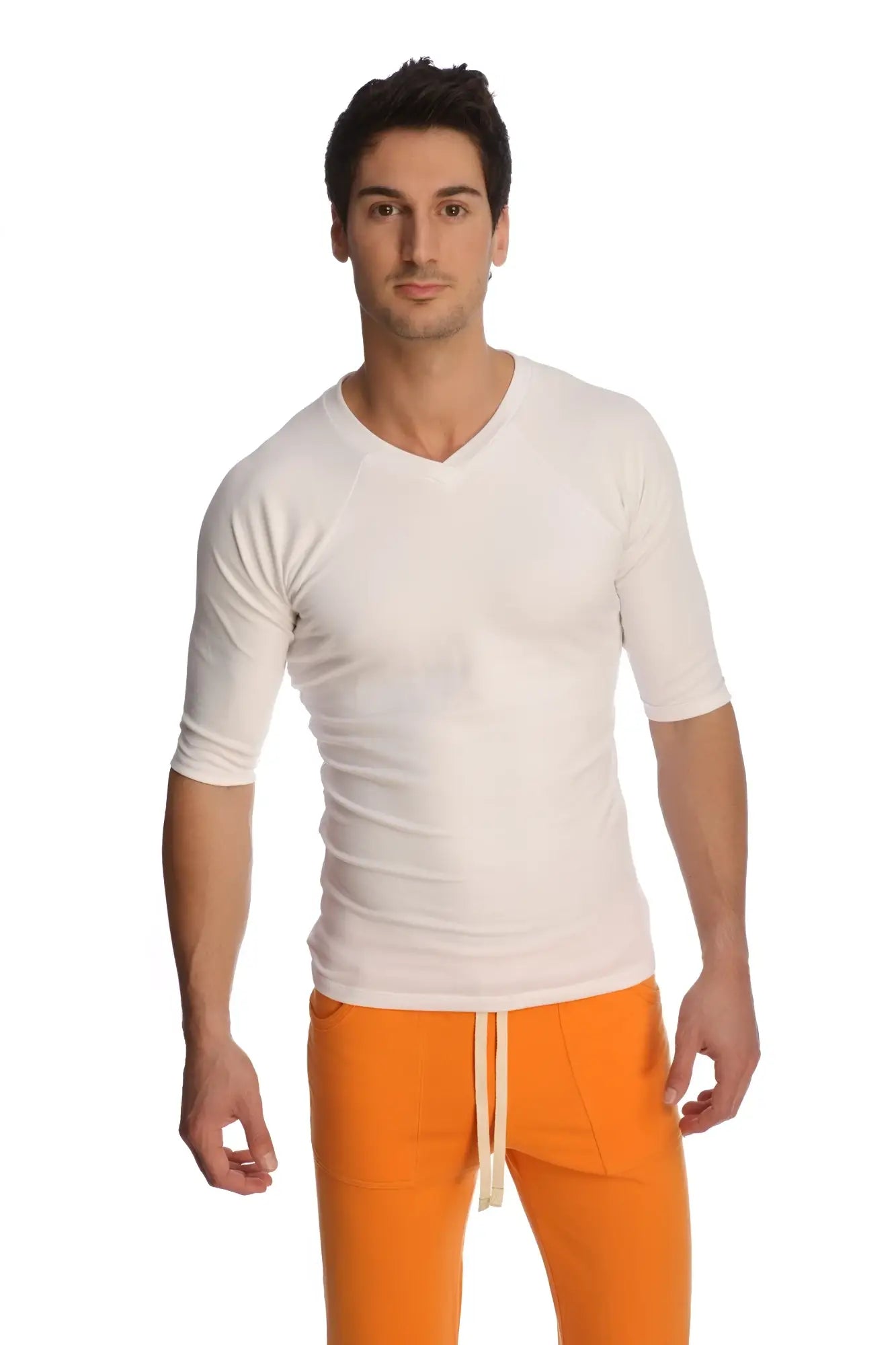 A man wearing a white raglan virtual crew neck shirt with three quarter sleeves and v neck style