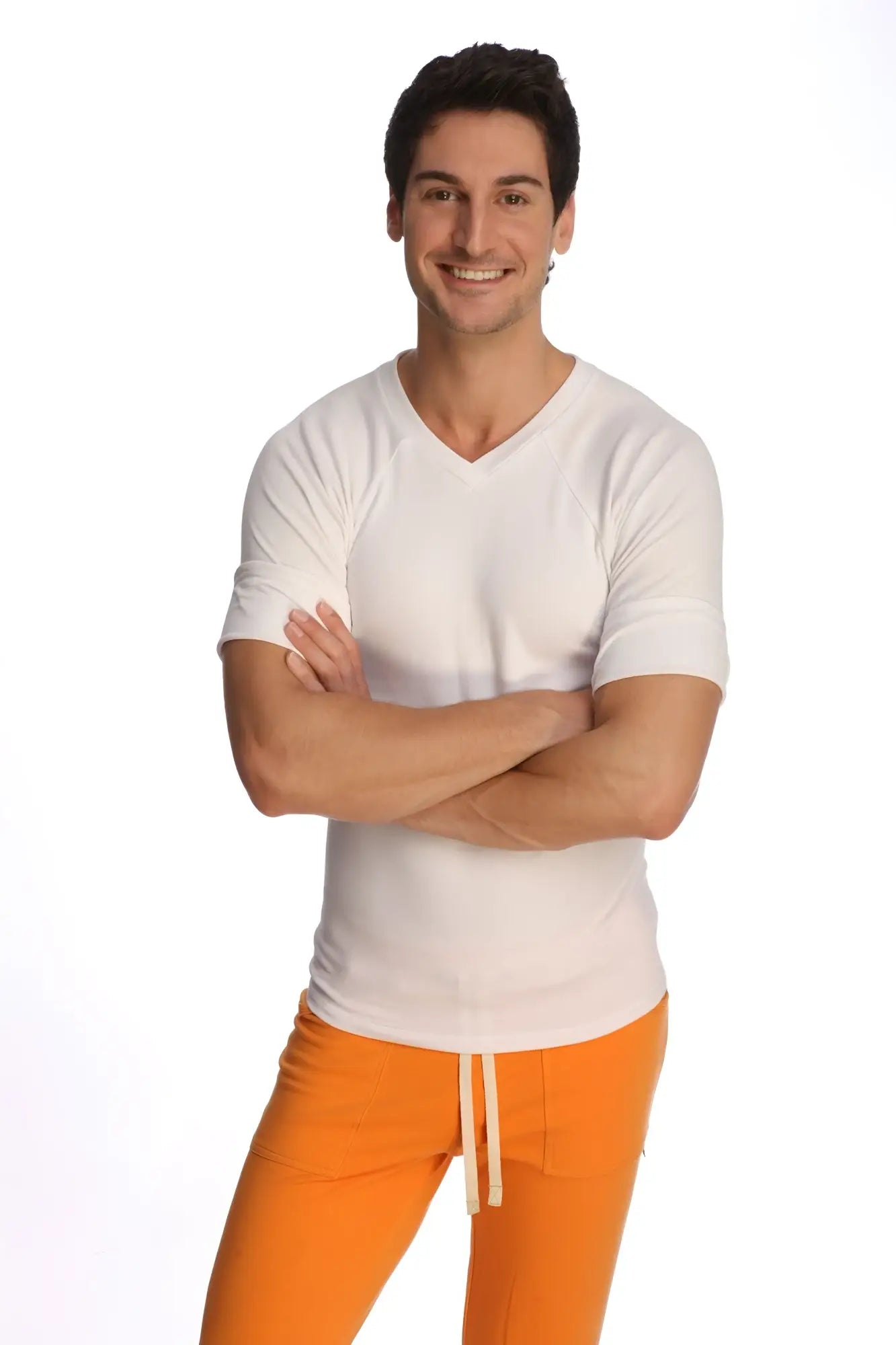 A man wearing a white raglan virtual crew neck v-neck shirt with short sleeves and bright orange drawstring pants
