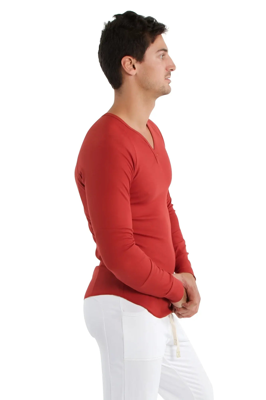 A man wearing a cinnabar thermal v-neck long sleeve shirt made of smooth fabric in a vibrant red color