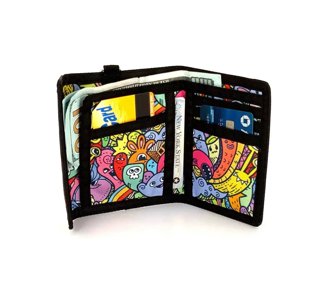 An 80s velcro tri-fold wallet with black trim and a colorful cartoon pattern of whimsical creatures and bold outlines