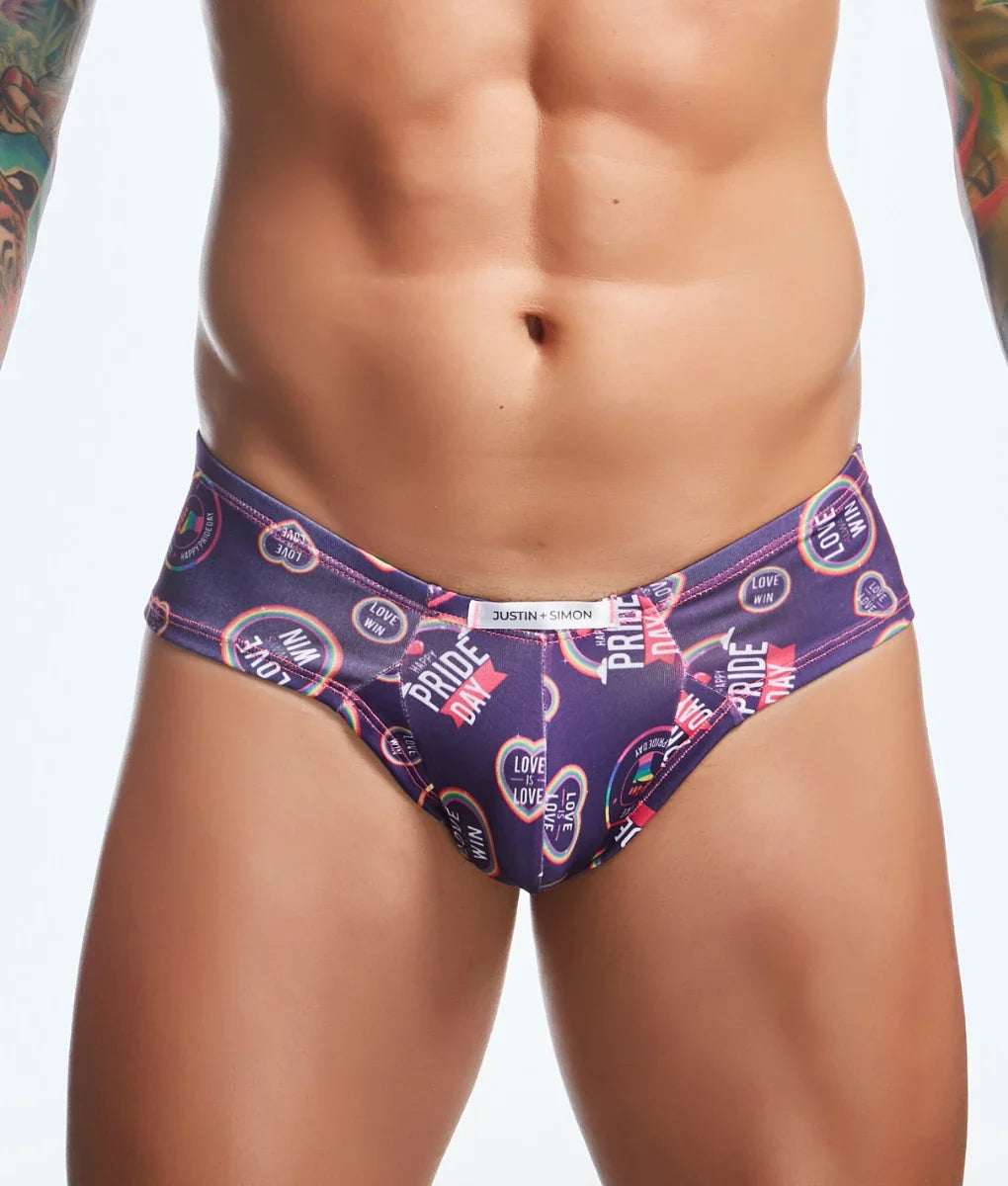 Purple Justin Simon swim trunks with vibrant pride day rainbow hearts and text in cheek fun prints design