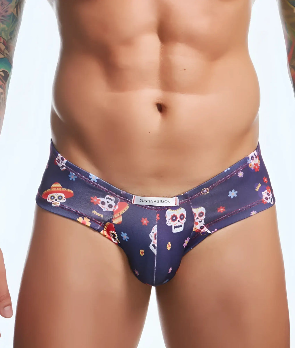 Dark blue men’s briefs with vibrant sugar skull pattern wearing sombreros and floral accents branded justin simon