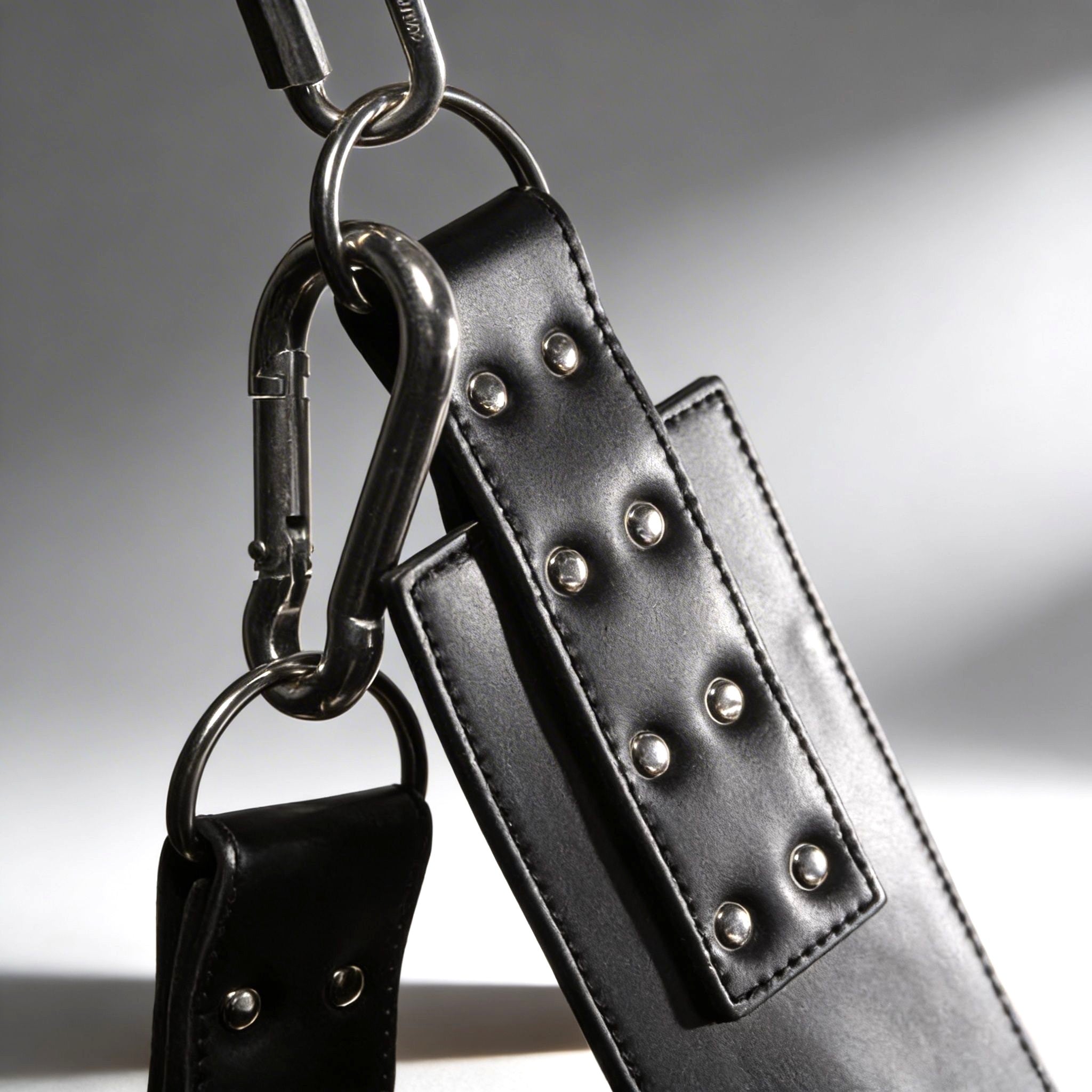 Strict Leather Lined Sling with black leather straps, silver metal rivets, and polished steel carabiner hardware.