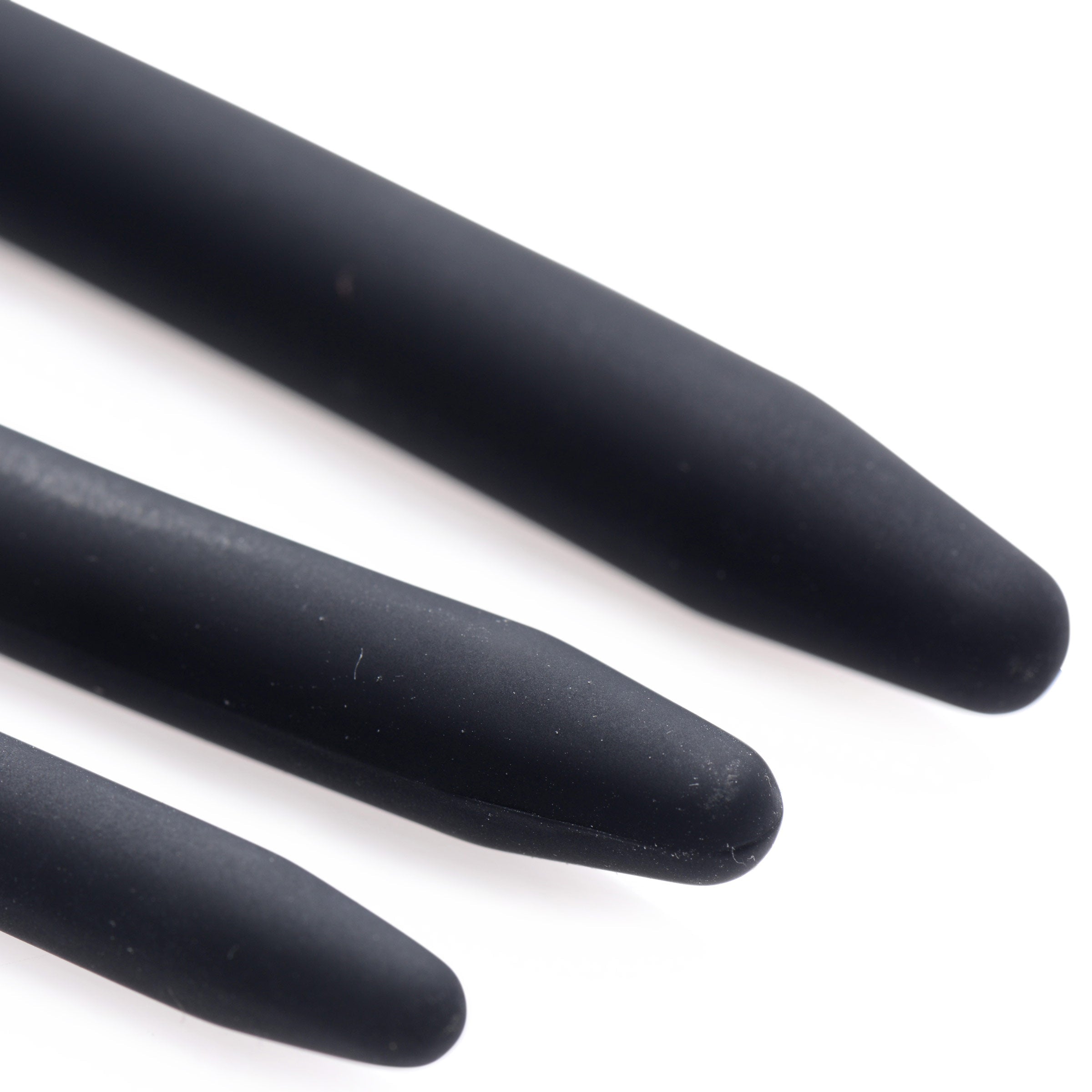 Close-up of three matte black Master Series Bolted Deluxe silicone urethral sounds with tapered, rounded tips.