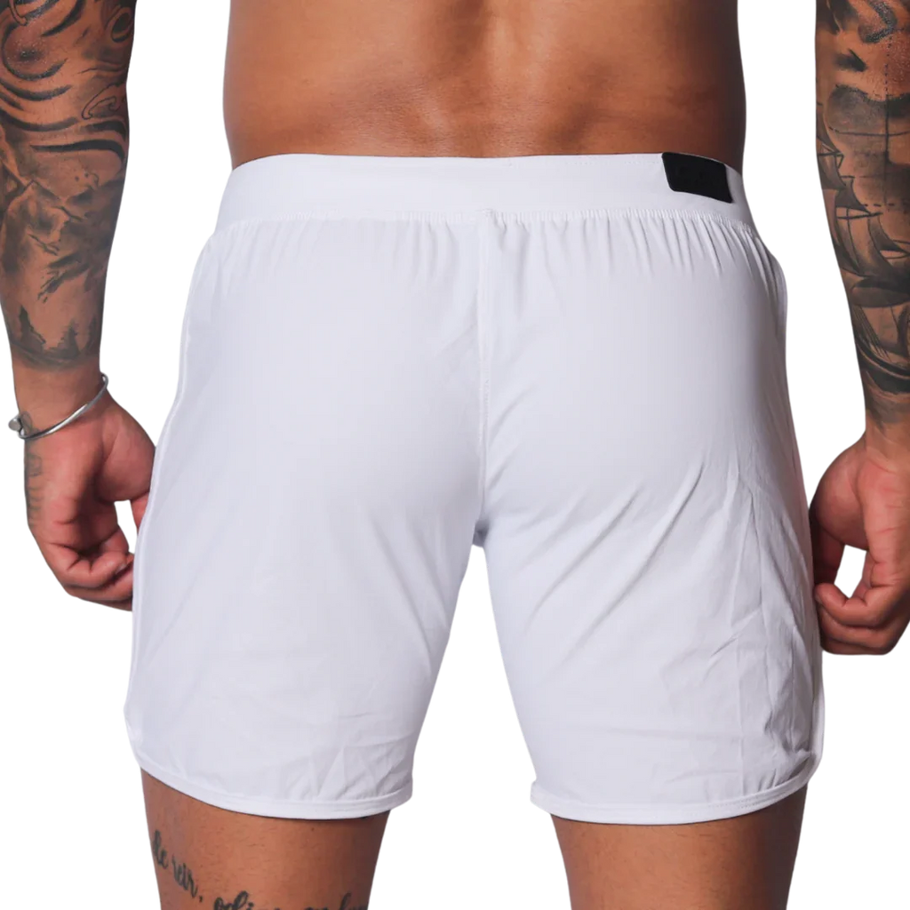 Plain white athletic shorts with a smooth, lightweight fabric, elastic waistband, and small black logo tab on the back.