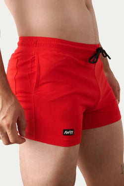 AWRY Menswear red Vers Short V2.1 with black drawstring, pockets, and black logo patch on left hem.